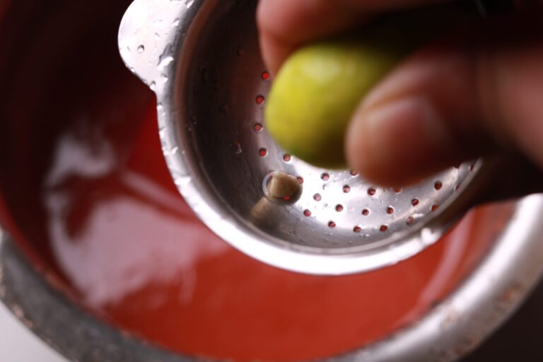 Lemon juice being stirred into the thickened guava jam