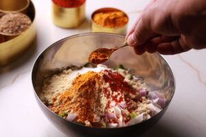 Adding spices and salt with a spoon