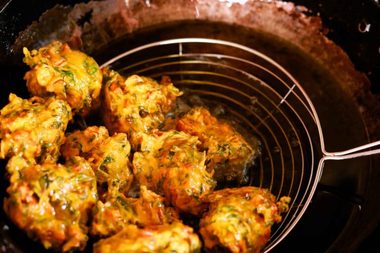 Crispy pakoras lifted from hot oil