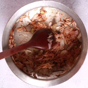 Add the sliced onions and fry until they turn golden brown.