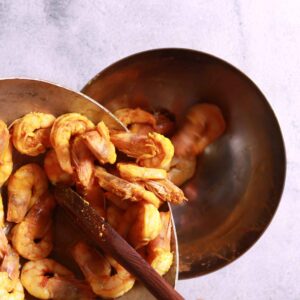 Removing sautéed prawns pan