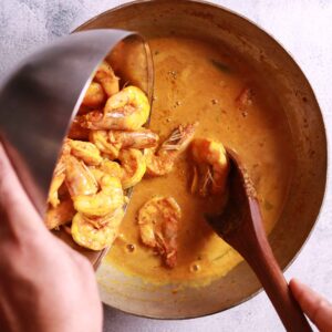 Adding prawns to chingri macher malai curry recipe