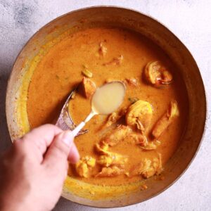 Finishing chingri macher malai curry with garam masala