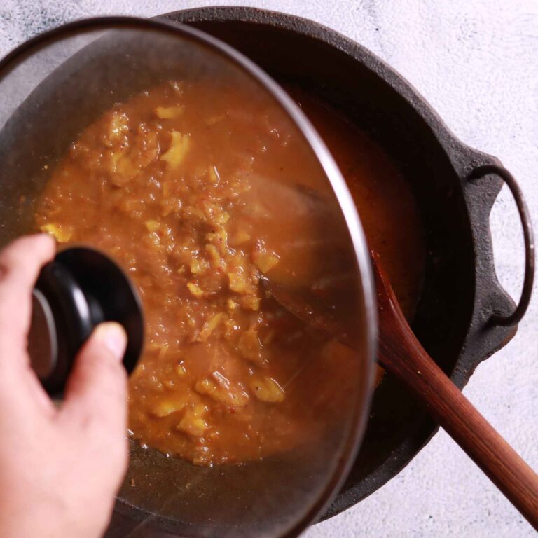 Covered pan simmering potato curry