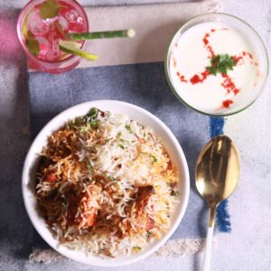Serving Paneer Tikka Biryani with raita