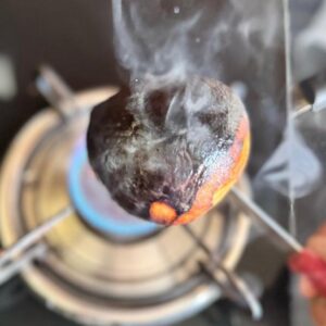 Roasting coconut over flame