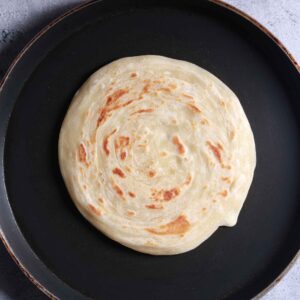 Cooking parotha on pan