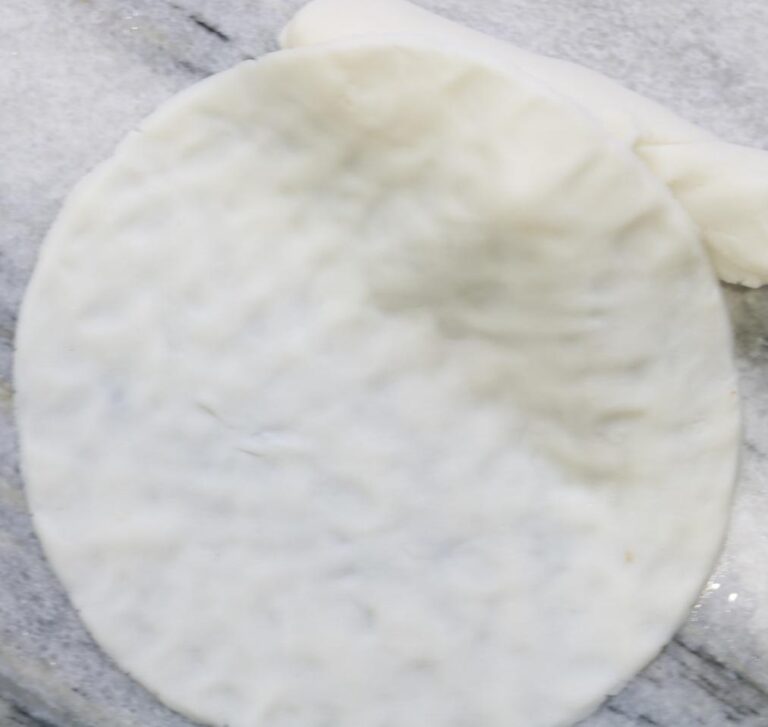 Hands shaping dough disc