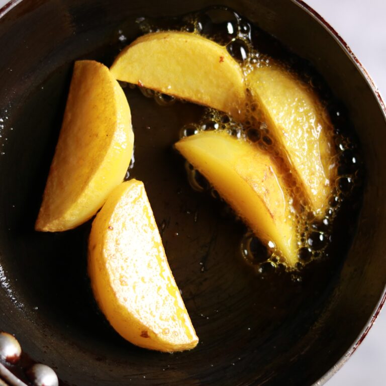 Golden potato wedges frying